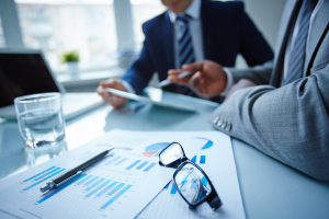 Image of eyeglasses and financial documents at workplace with bu