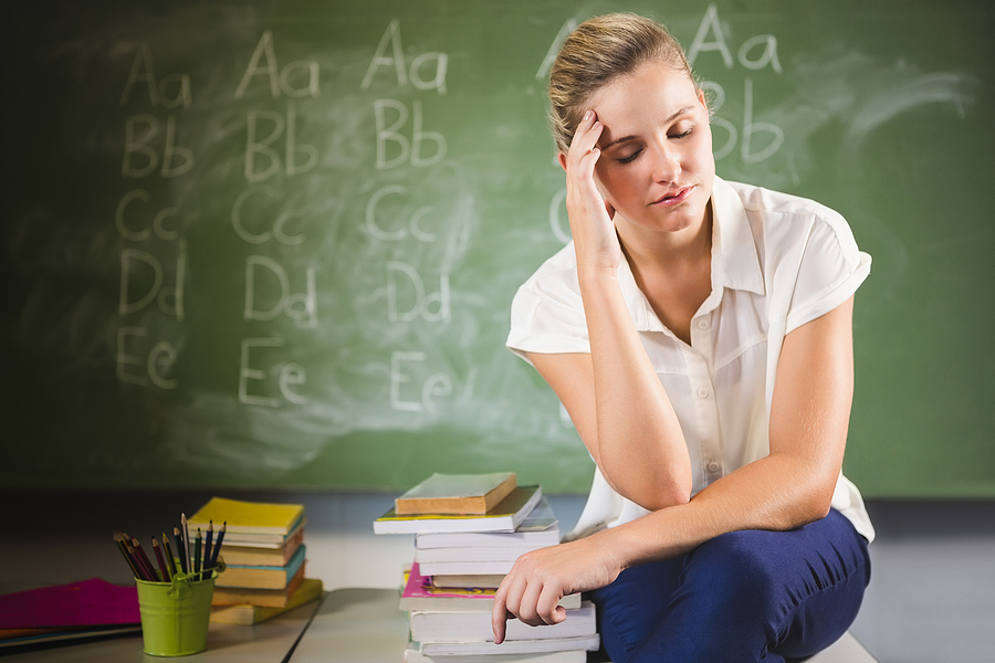 bigstock-Tensed-school-teacher-sitting-139644923